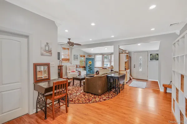 a living room with furniture a flat screen tv and a wooden floor