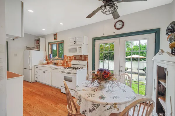 a kitchen with furniture a large window appliances and a dining table