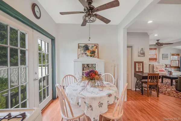 a dining room with furniture a floor to ceiling window and wooden floor