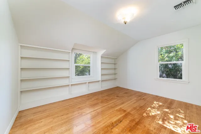 a view of empty room with window and wooden floor