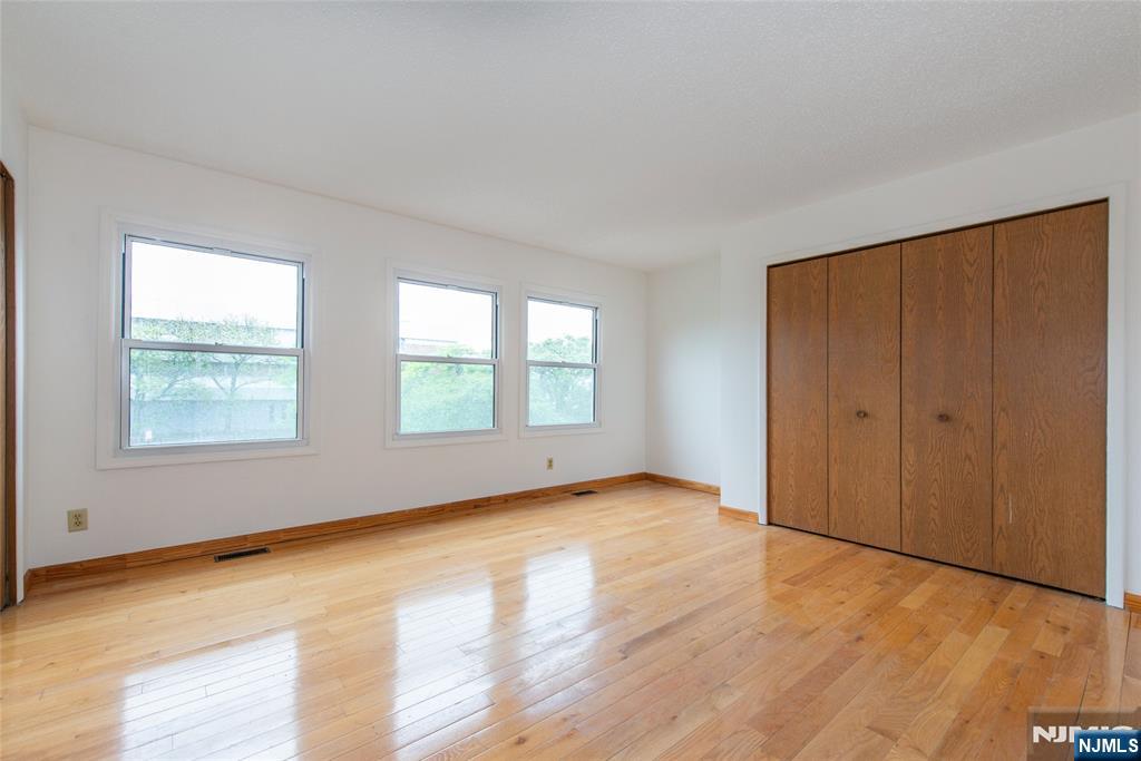 553 Ocean Avenue Jersey City, NJ 07305 - Photo 14 of 27 an empty room with wooden floor and windows