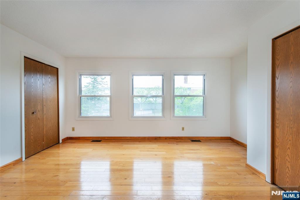 553 Ocean Avenue Jersey City, NJ 07305 - Photo 15 of 27 an empty room with wooden floor and windows