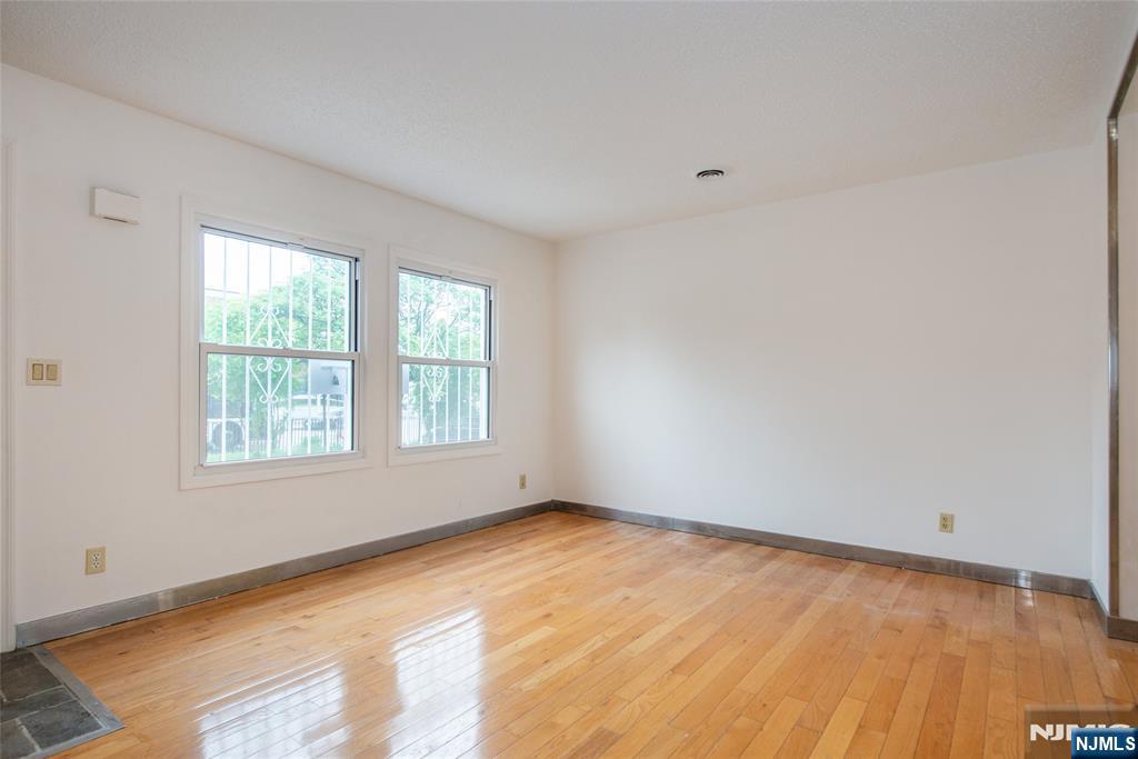 553 Ocean Avenue Jersey City, NJ 07305 - Photo 3 of 27 a view of an empty room with wooden floor and a window