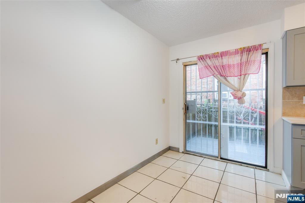 553 Ocean Avenue Jersey City, NJ 07305 - Photo 8 of 27 a view of an empty room with wooden floor and a window
