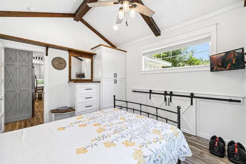 a bedroom with a bed a window and dresser