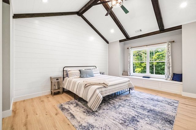 a bedroom with a bed and a large window