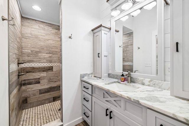 a bathroom with a granite countertop sink and a mirror