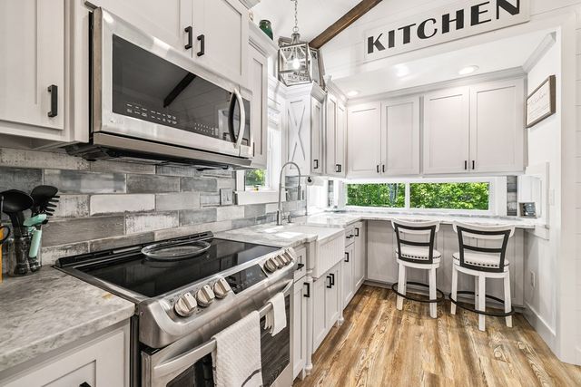 a kitchen with a stove a sink and a microwave