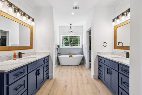 a spacious bathroom with a granite countertop tub sink and mirror
