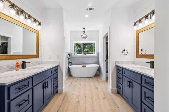 a spacious bathroom with a granite countertop tub sink and mirror