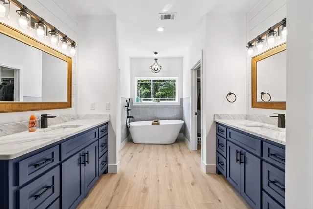 a spacious bathroom with a granite countertop tub sink and mirror