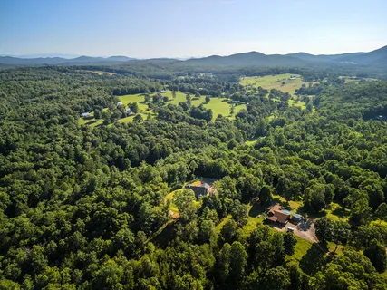 an aerial view of a house with a yard and swimming pool