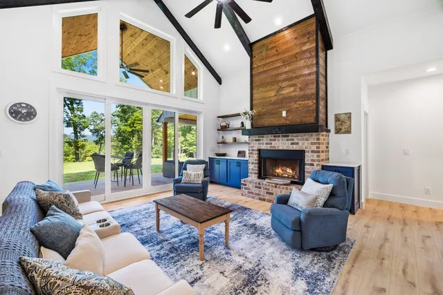 a living room with furniture a large window and a fireplace