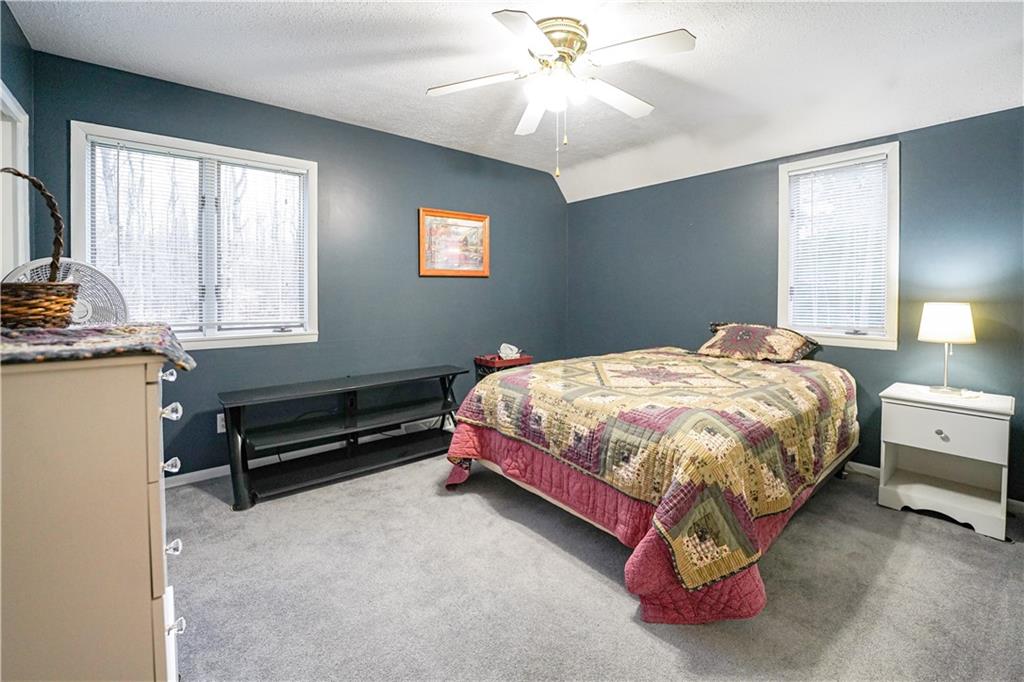 809 Enterprise Road Grove City, PA 16127 - Photo 34 of 43 a bedroom with a bed and a chandelier