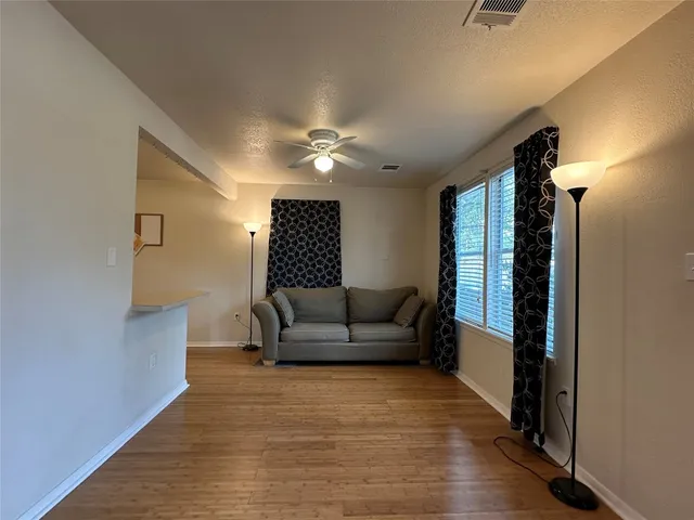 a living room with furniture and a ceiling fan