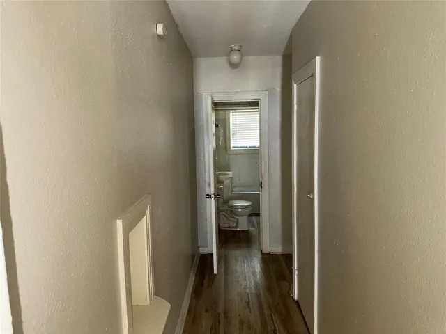 a view of a hallway with a livingroom and a bathroom with sink