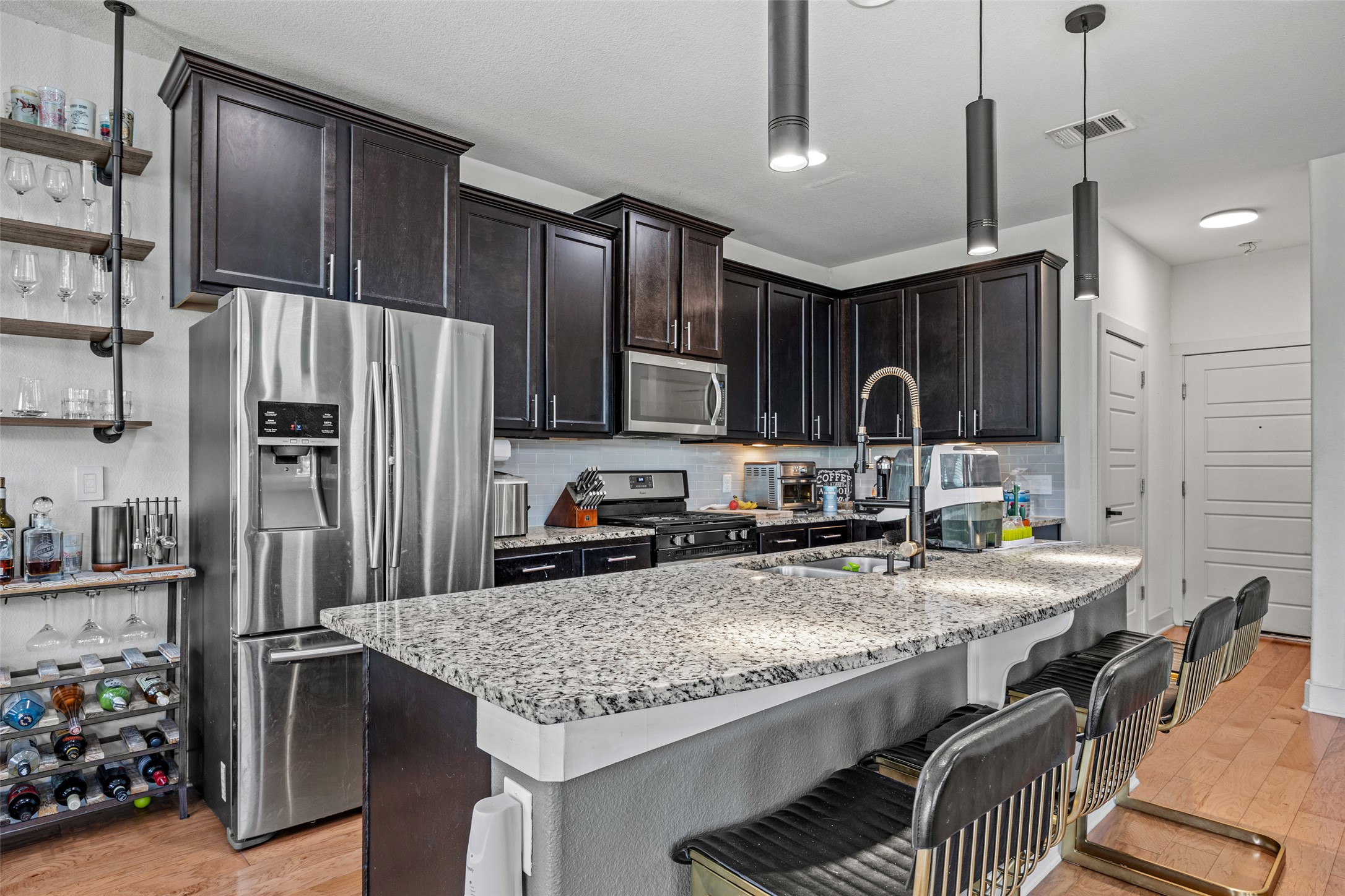 1408 Homespun Road Austin, TX 78745 - Photo 8 of 20 Culinary delights await in this modern kitchen with ample counter space and inviting bar seating.