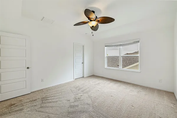 an empty room with windows and fan