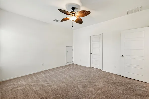 an empty room with a window and a fan