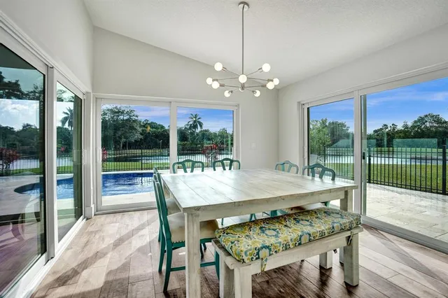 a dining room with furniture a chandelier and wooden floor