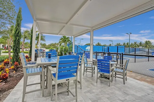 a view of a chairs and table in patio next to a yard