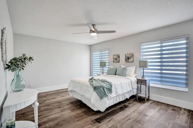 a bedroom with a bed lamp and a potted plant