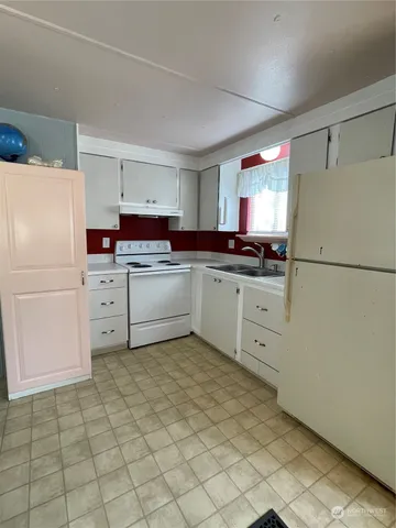 a kitchen with stainless steel appliances a refrigerator sink and cabinets