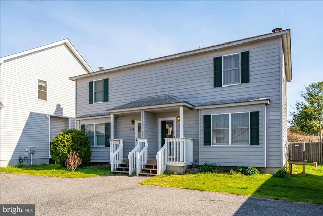 a view of a house with small yard plants and palm tree