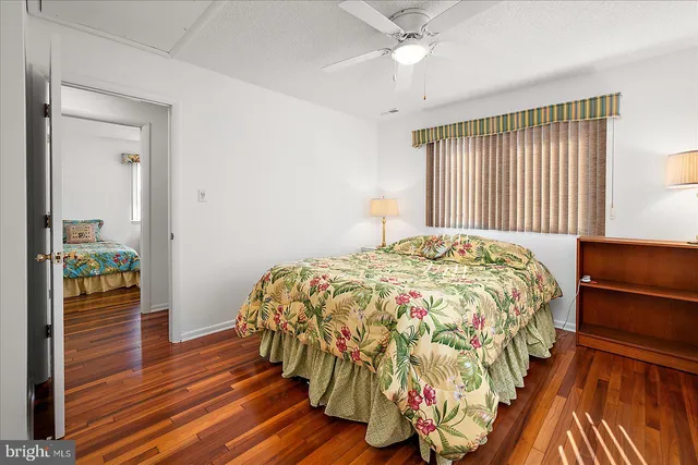 a bedroom with a bed and a chandelier fan