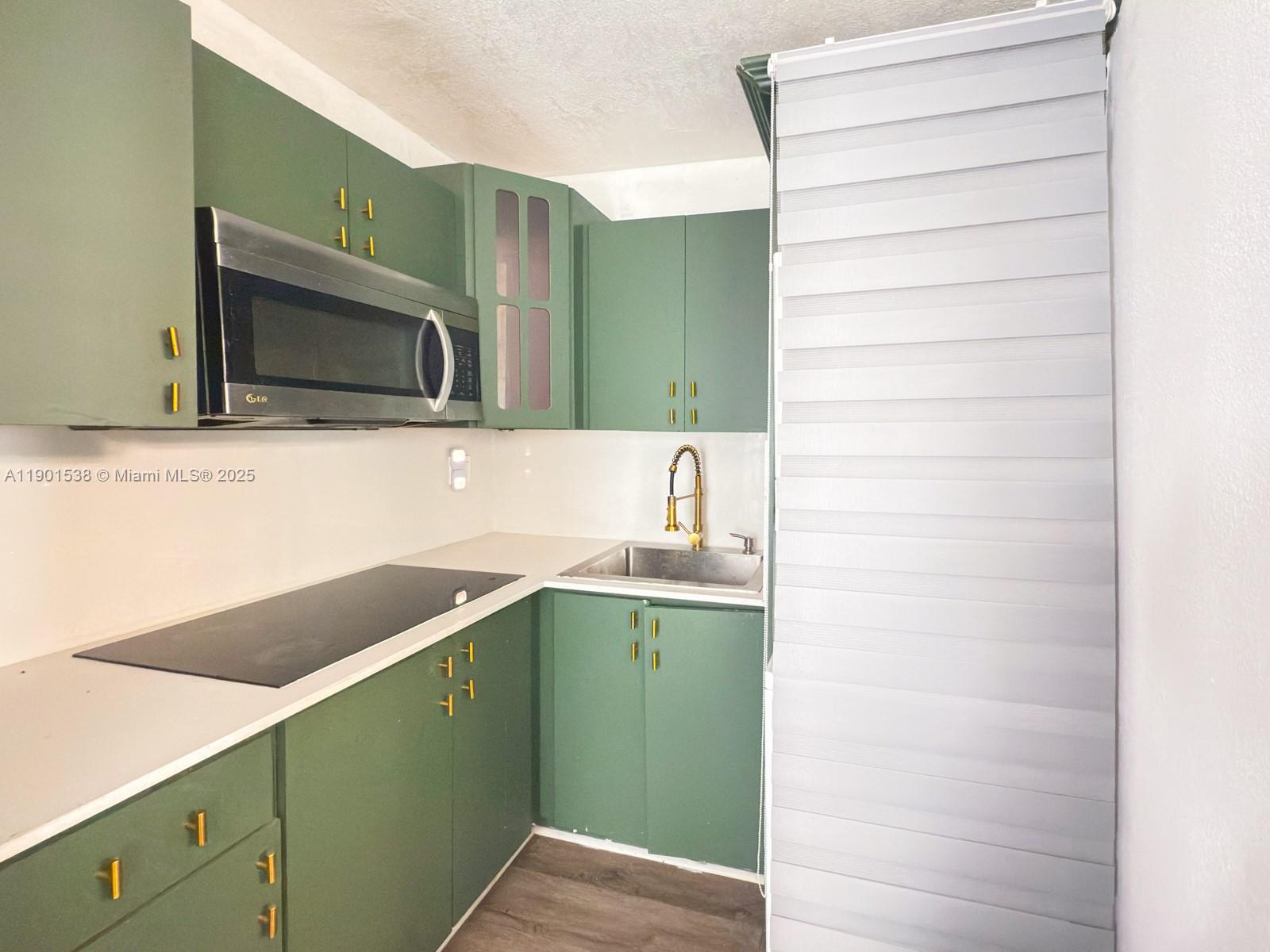 7928 Harding Avenue, Unit 2 Miami Beach, FL 33141 - Photo 7 of 19 a kitchen with a sink and a microwave
