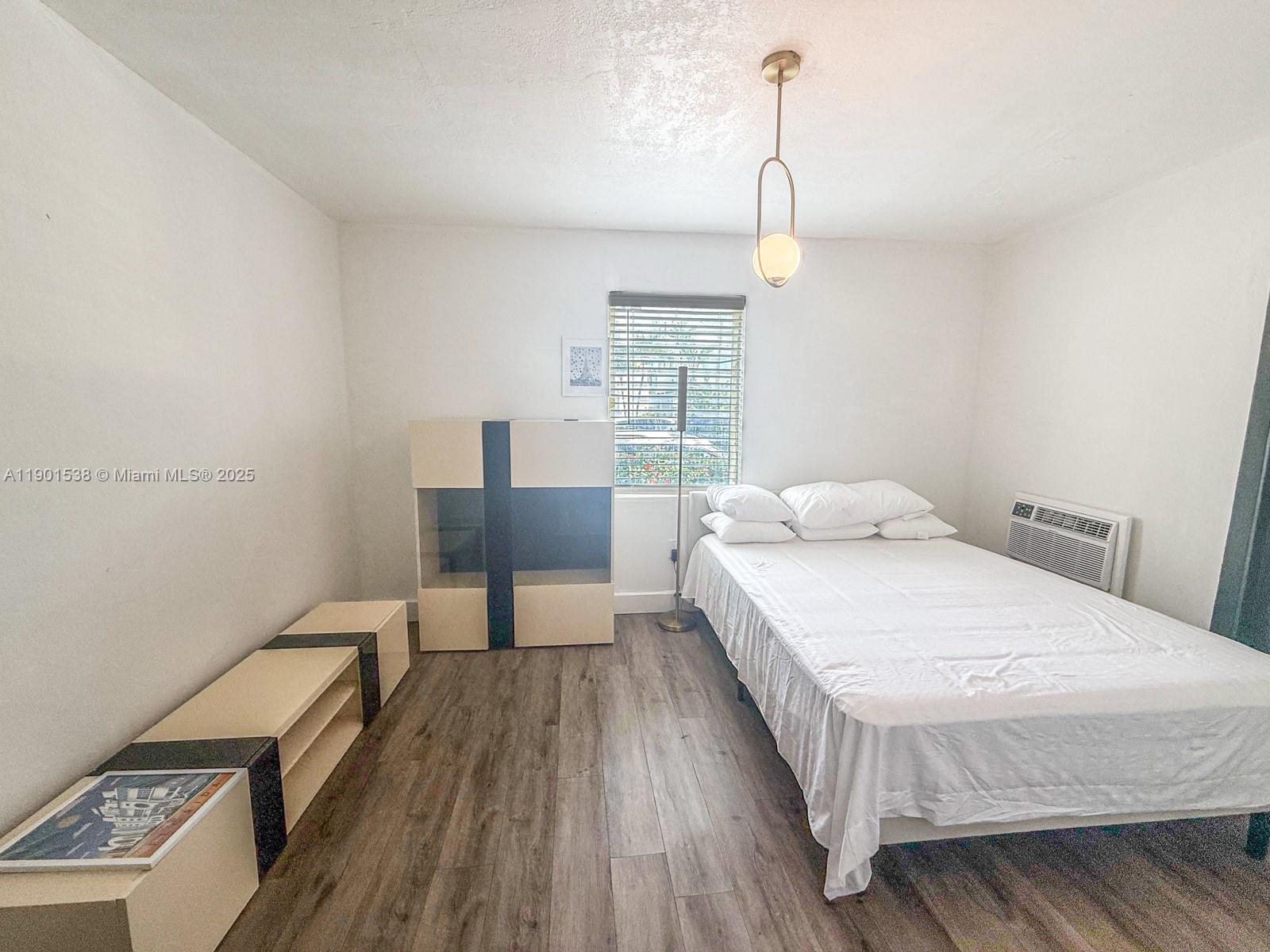 7928 Harding Avenue, Unit 2 Miami Beach, FL 33141 - Photo 8 of 19 a bedroom with a bed and wooden floor