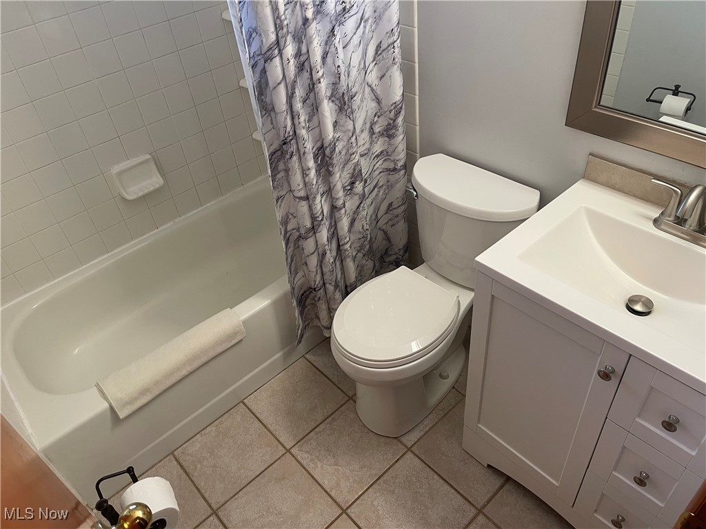 835 Pendley Road Willowick, OH 44095 - Photo 20 of 27 Bathroom featuring vanity, shower / bath combo with shower curtain, and light tile patterned floors