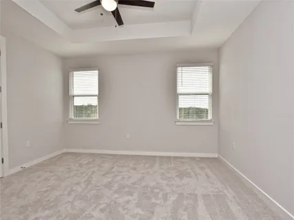 an empty room with a window and a ceiling fan