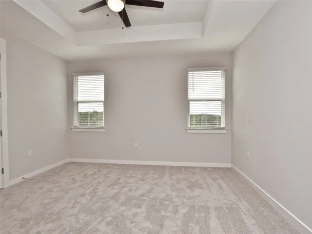 an empty room with a window and a ceiling fan