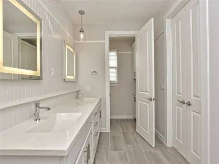 a bathroom with a double vanity sink a mirror and a shower