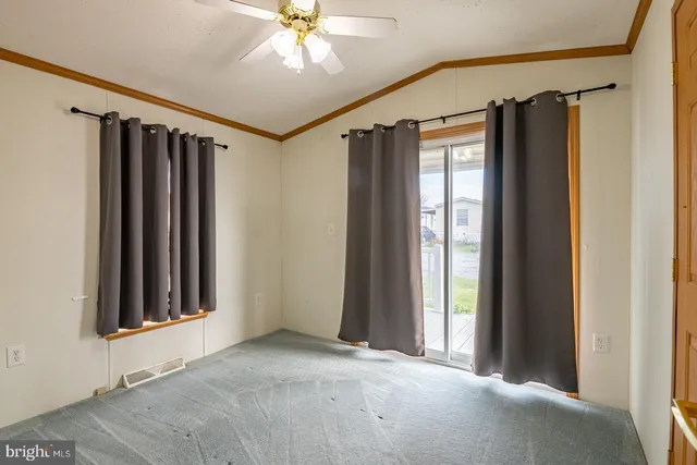 a view of a hallway with a windows and ceiling fan