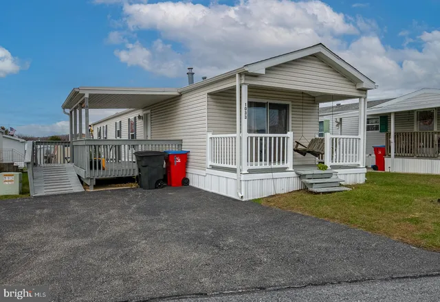 a view of house with a big yard and large trees