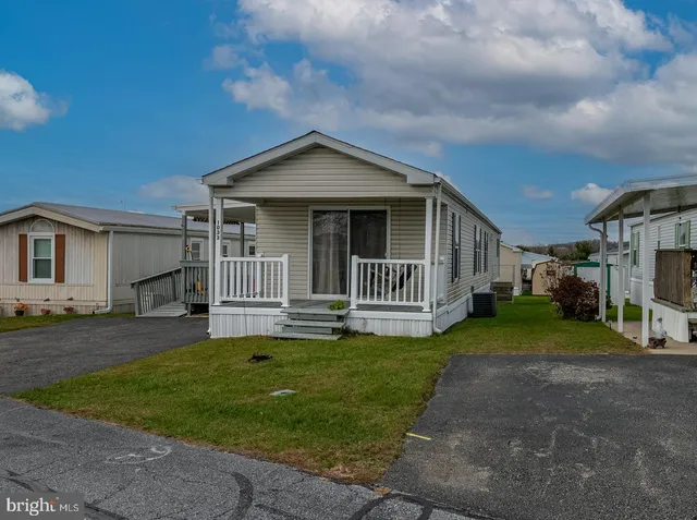 a view of a house with a yard and pathway