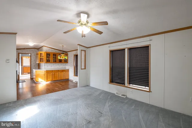 a view of an empty room with window and wooden floor