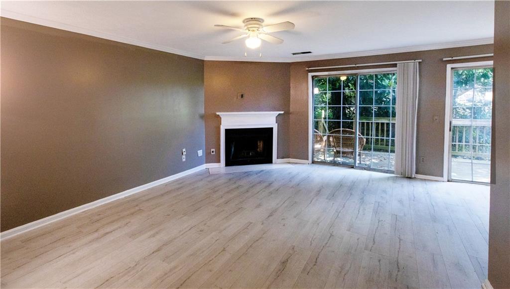 a view of empty room with wooden floor and fireplace
