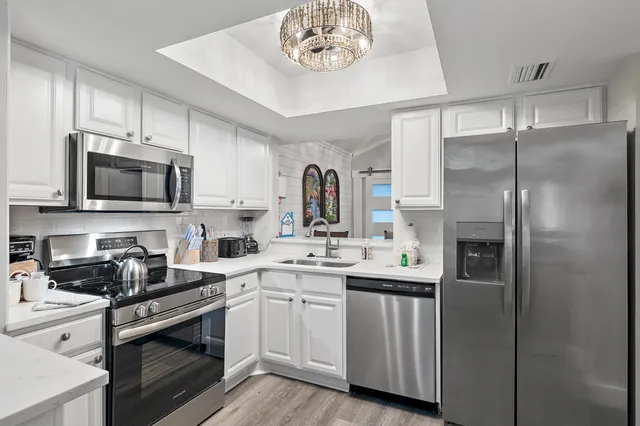a kitchen with a sink stainless steel appliances and cabinets