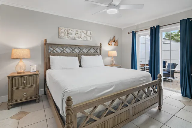 a bedroom with a bed a mirror on dresser and a window