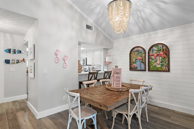 a view of a dining room with furniture and a chandelier