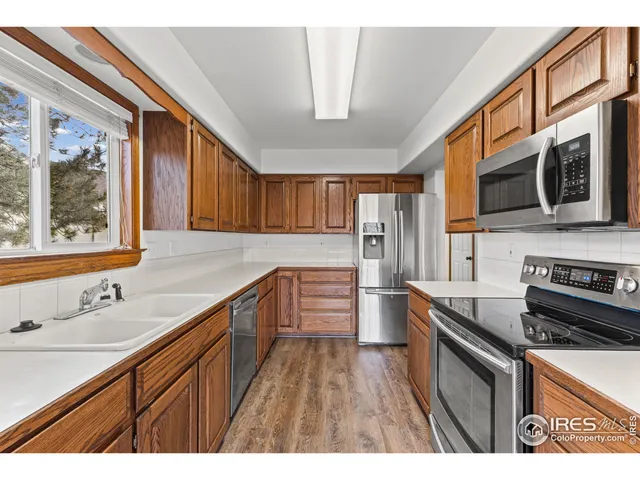a kitchen with stainless steel appliances kitchen island granite countertop a sink stove microwave and refrigerator