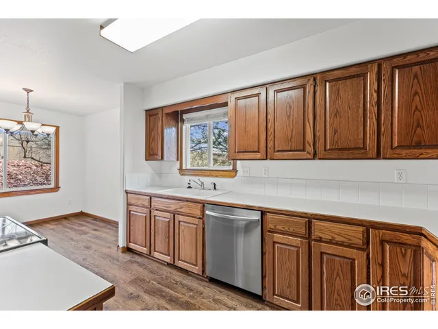 a kitchen with stainless steel appliances granite countertop a sink dishwasher stove and cabinets with wooden floor