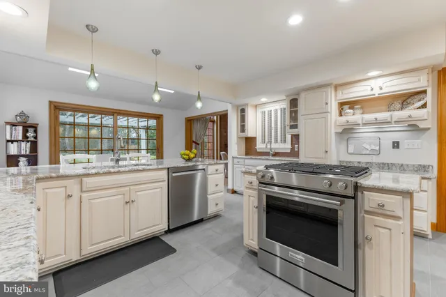 a kitchen with granite countertop white cabinets and stainless steel appliances