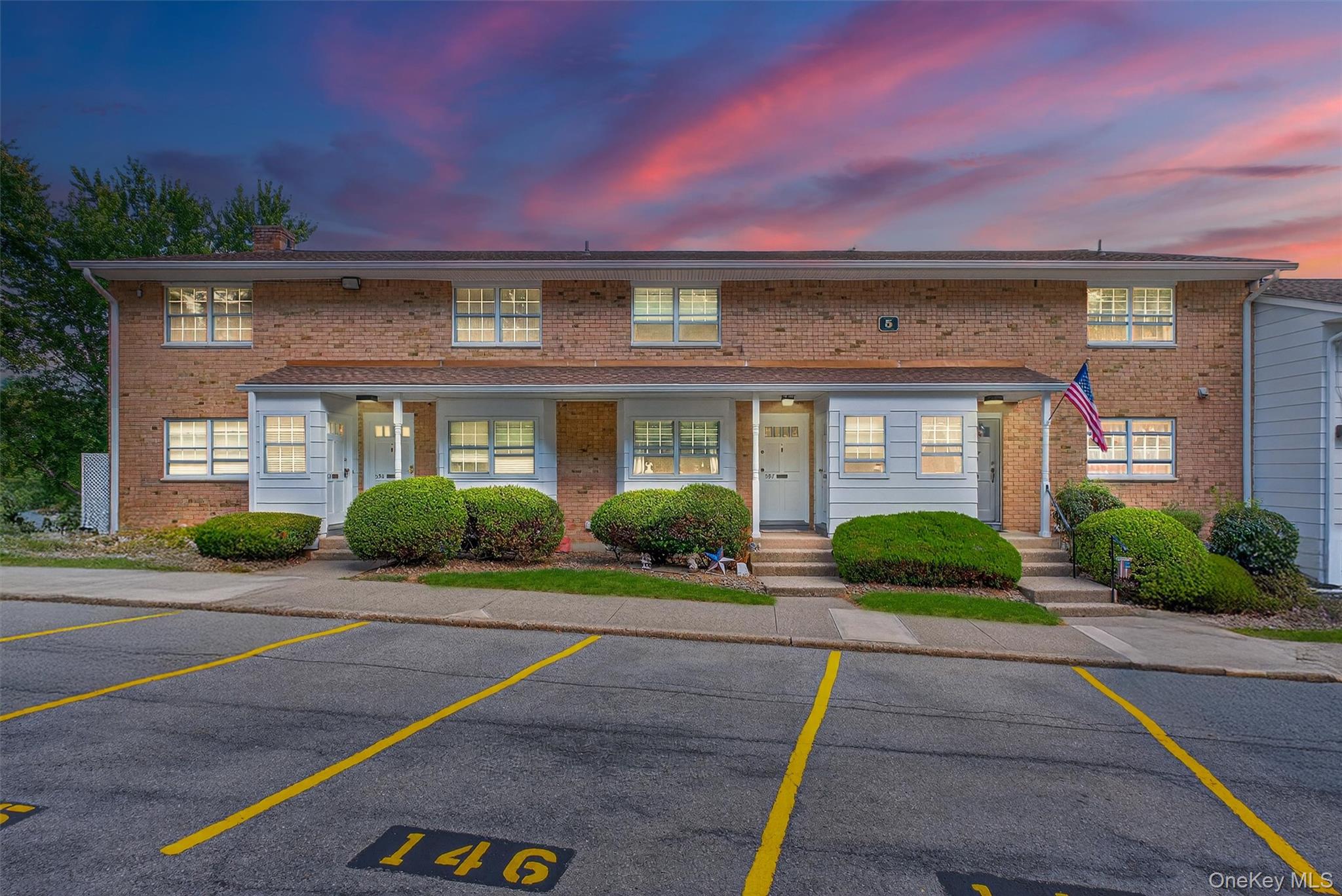 a front view of a house with yard and green space