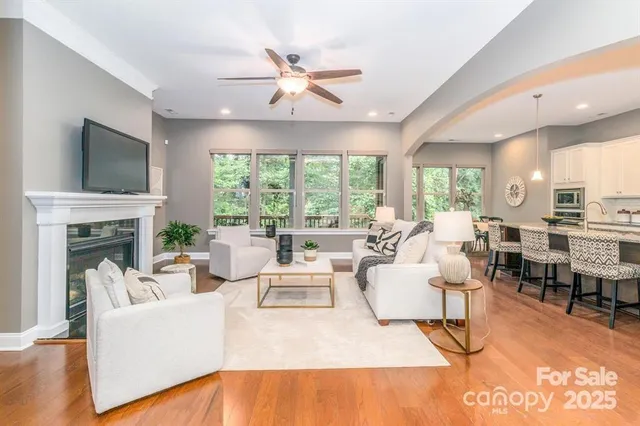 a living room with fireplace furniture and a large window