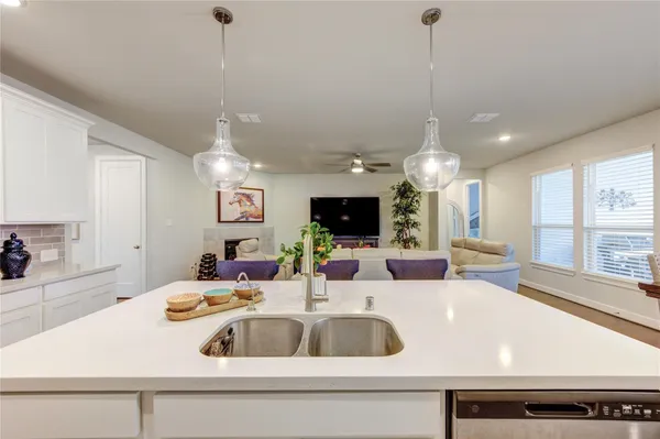 a kitchen with a sink a large window and a chandelier