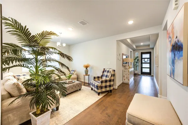 a living room with furniture and a wooden floor
